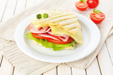 Tasty sandwich with ham on wooden table