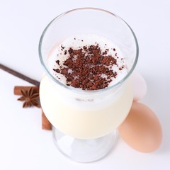 Eggnog with spices isolated on white