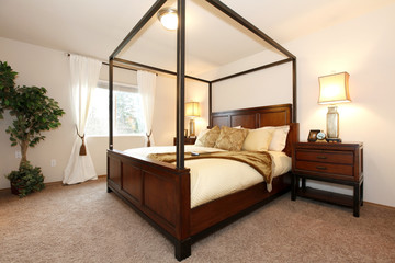 Warm beautiful bedroom with a high posts bed