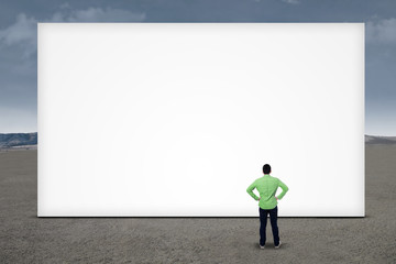Businessman standing in front of blank board