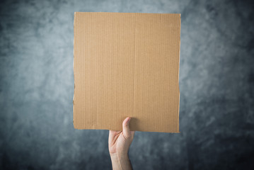 Man holding blank cardboard paper