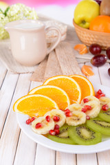 Sweet fresh fruits on plate on table close-up