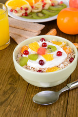 Delicious oatmeal with fruit in bowl on table close-up