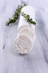 Tasty bushe cheese with thyme, on wooden table