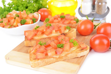 Delicious bruschetta with tomatoes on cutting board close-up