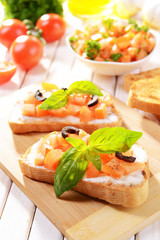 Delicious bruschetta with tomatoes on cutting board close-up