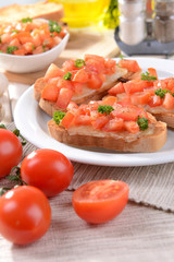 Delicious bruschetta with tomatoes on plate on table close-up