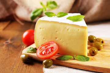 Tasty Camembert cheese with tomatoes, olives and basil,