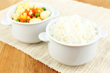 Cooked rice with vegetables on wooden table close up