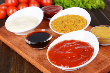 Various sauces on chopping board on table close-up