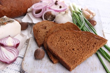 Rye bread with lard and onion on table close up