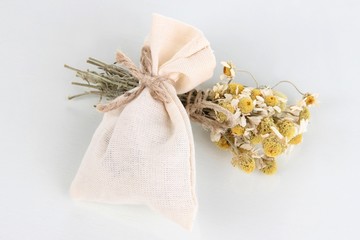 Obraz na płótnie Canvas Textile sachet pouch with dried flowers isolated on white