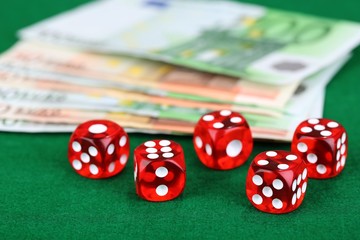 Red dices and money, on green background