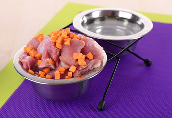 Natural food for pets and water in bowls on floor