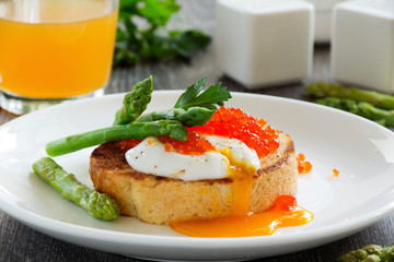 Fresh toast with poached egg, caviar and asparagus.
