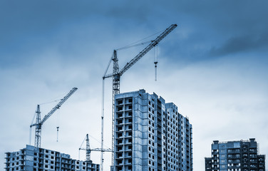 Fototapeta na wymiar Tower cranes and modern buildings under construction