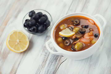 Solyanka - russian soup with meat, sausages, olives and lemon