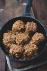 Cast-iron frying pan with meatballs, vertical shot