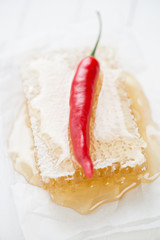 Red chili pepper atop of a honeycomb, shallow depth of field