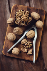 Above view of a rustic wooden chopping board with walnuts