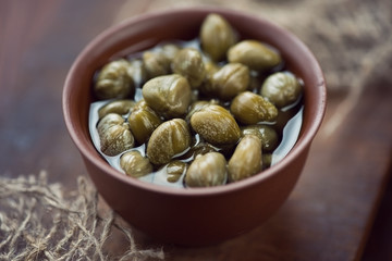 Close-up of a ceramic pialat with marinated capers