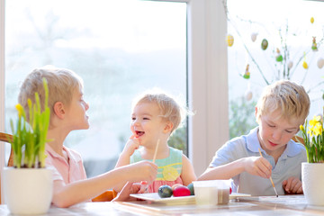 Group of cute kids decorating Easter eggs