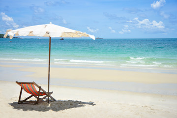 Beach chairs and umbrella on stunning tropical beach