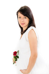 Beautiful pregnant woman with a red rose flower