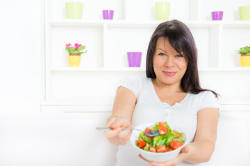 Healthy eating - Portrait of a beautiful pregnant woman eating fresh vegetable salad