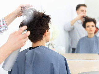 Brown Hair. The Hairdresser doing Hairstyle in Hair Salon. 