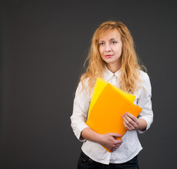 Smiling business woman with paper folders on gray background.