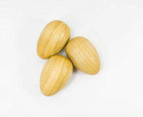 Three wooden egs on the white background