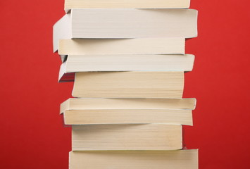 Stack of Paperback books on a red background - obrazy, fototapety, plakaty