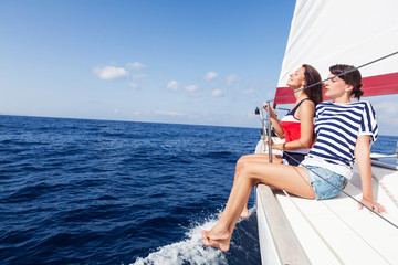 Happy women on the bow of a Sail Boat. Copy space