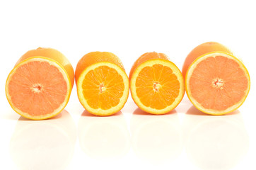 Half slices of grapefruit and oranges in a row.Isolated on white
