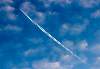 Airplane vapor trails in the clouds