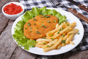 Schnitzel and fries with sauce and lettuce