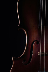 Scratched violin on dark background. Closeup view.