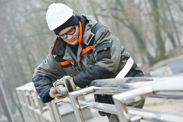 worker polishing metal fence barrier