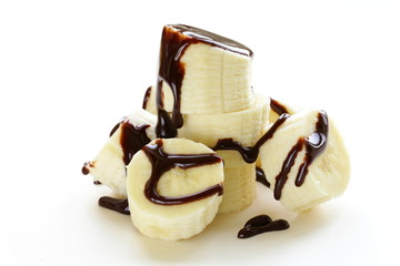 fresh ripe banana with chocolate sauce on white background © Olga Kriger