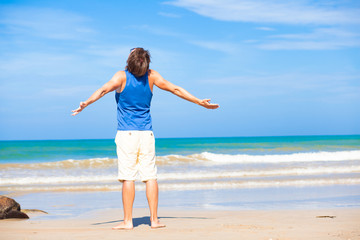 Fototapeta na wymiar man waving hands at the beach, enjoying his time tanning