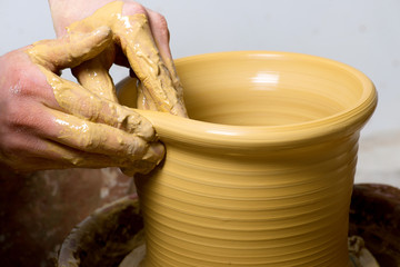 hands of a potter, creating an earthen jar