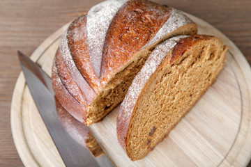 The cut black bread on a wooden table
