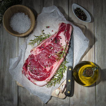 Chulet&oacute;n de ternera crudo sobre la mesa de la cocina