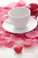 Obraz na płótnie Canvas Coffee cup and rose petals