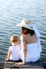 Mother and son sitting on a wooden jetty