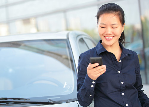 Beautiful Asian Businesswoman Use Smart Phone Leaning On Car