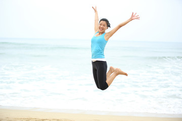 Obraz premium Happy woman jumping on the beach. summer holidays