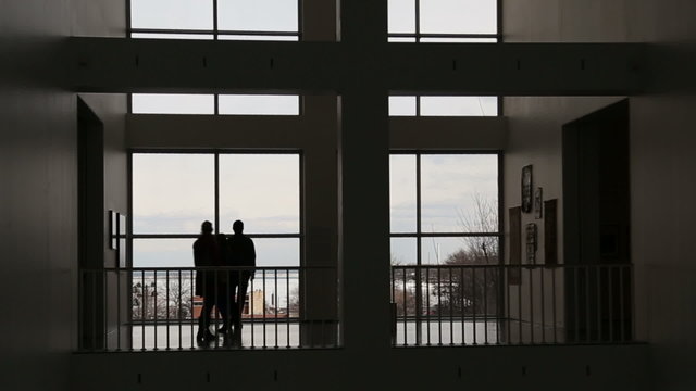 Silhouette of people in hallway or gallery, video