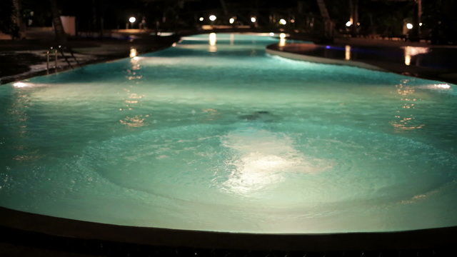 Man Jumping Into Swimming Pool In The Night